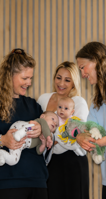 Forældre og babyer deltager på babytummel i trygge rammer hos Strib Familiefys